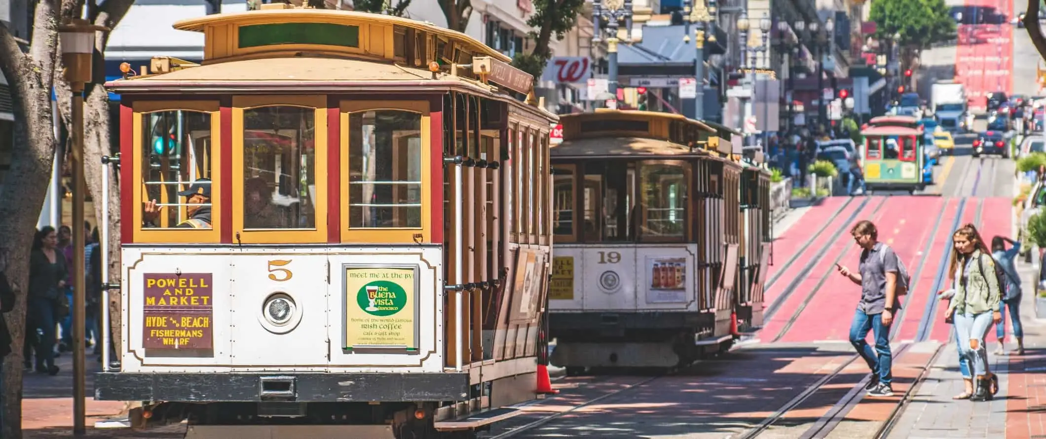 Cilvēki iekāpj divos vēsturiskos ratiņos Sanfrancisko, Kalifornijā.