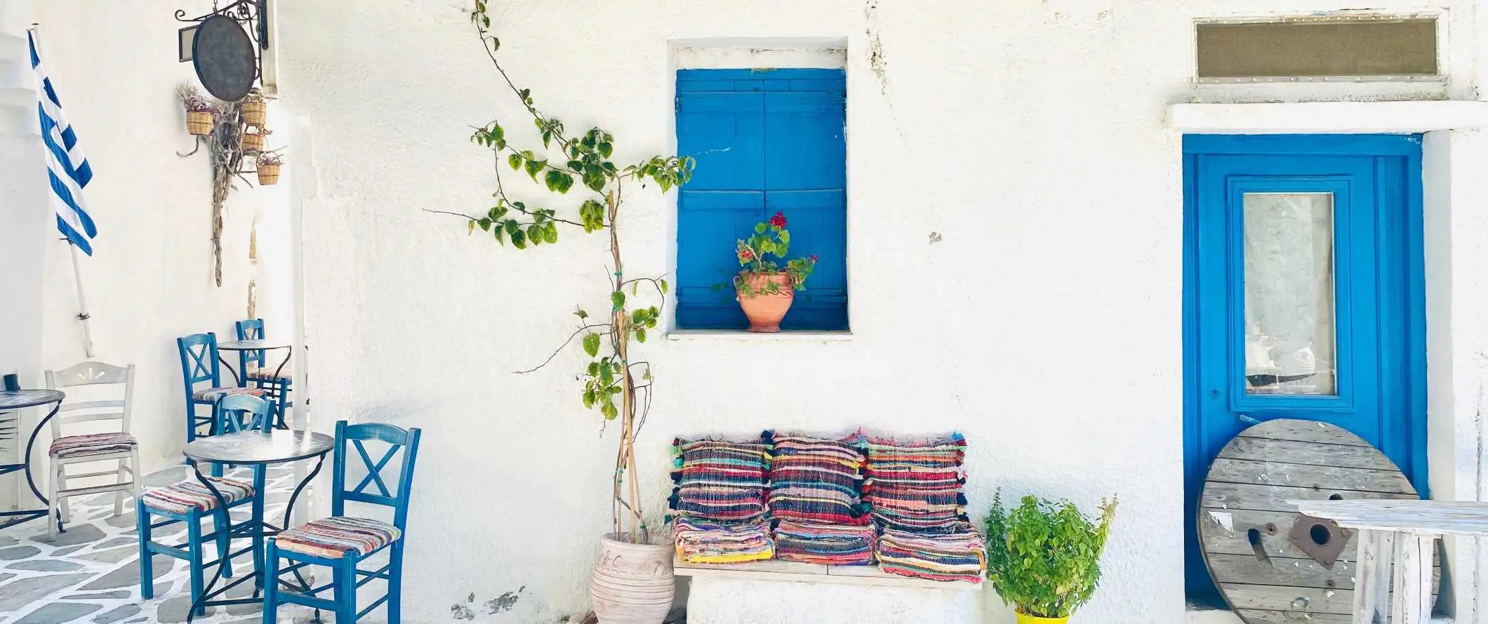 Edificio encalado con marcos de puertas y ventanas azules en Naxos, Grecia.