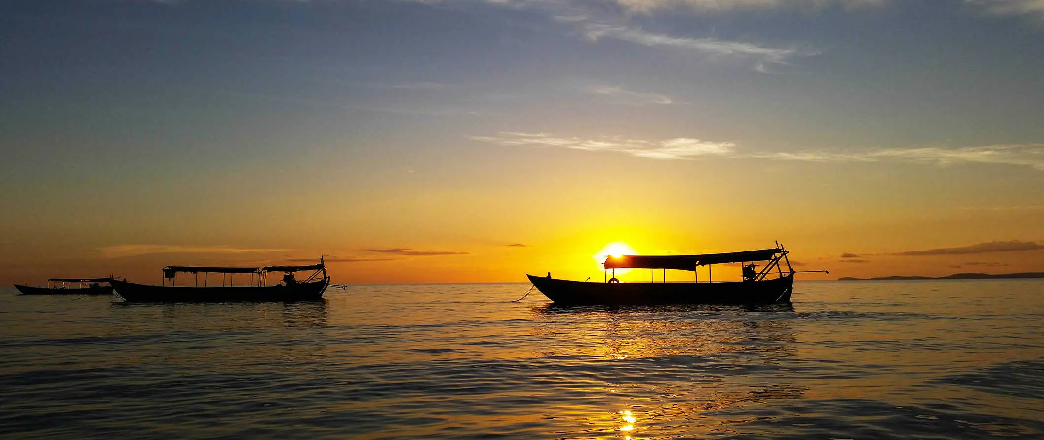 Pequeñas embarcaciones en las tranquilas aguas al atardecer en Sihanoukville, Camboya