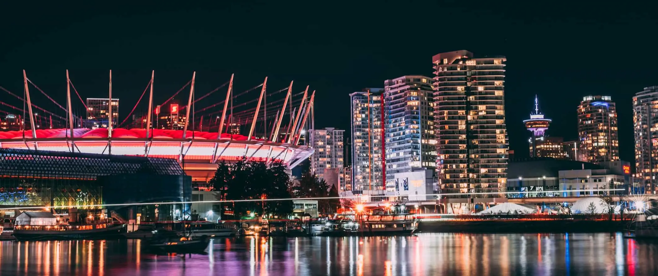 Die Skyline von Vancouver, Kanada, leuchtet nachts am Wasser auf