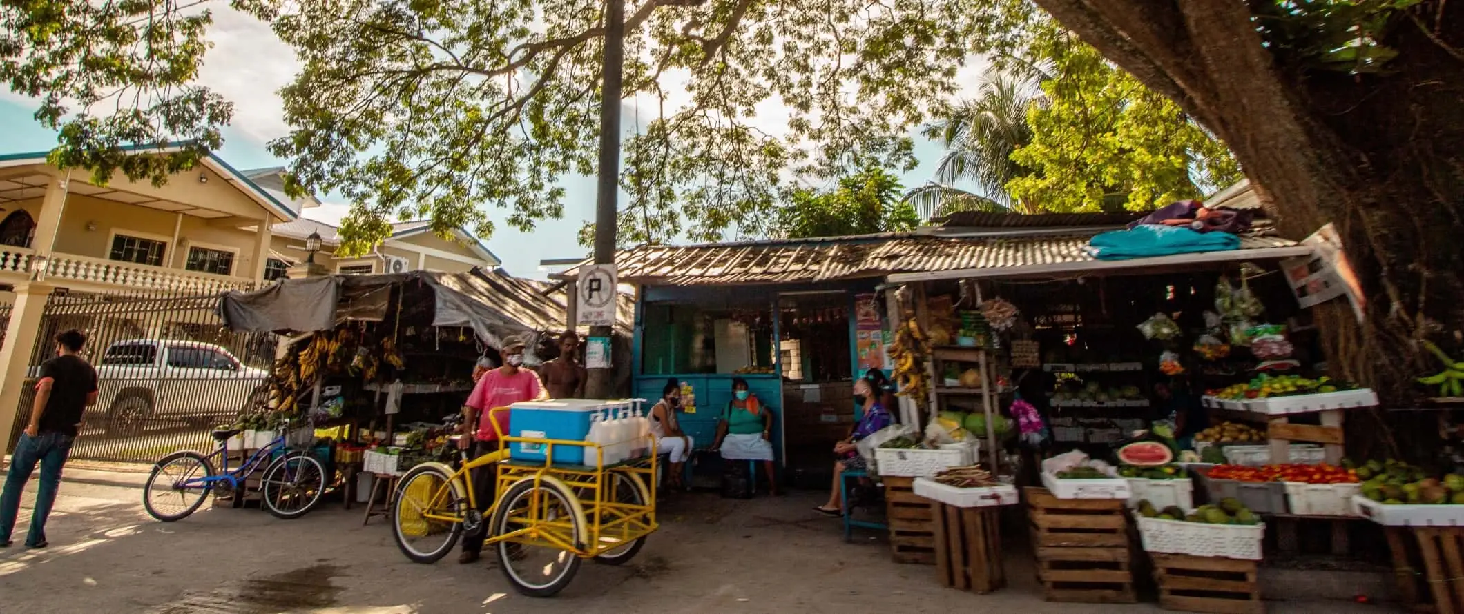 Scène de rue avec des gens rassemblés sur des stands de produits à Orange Walk, Belize