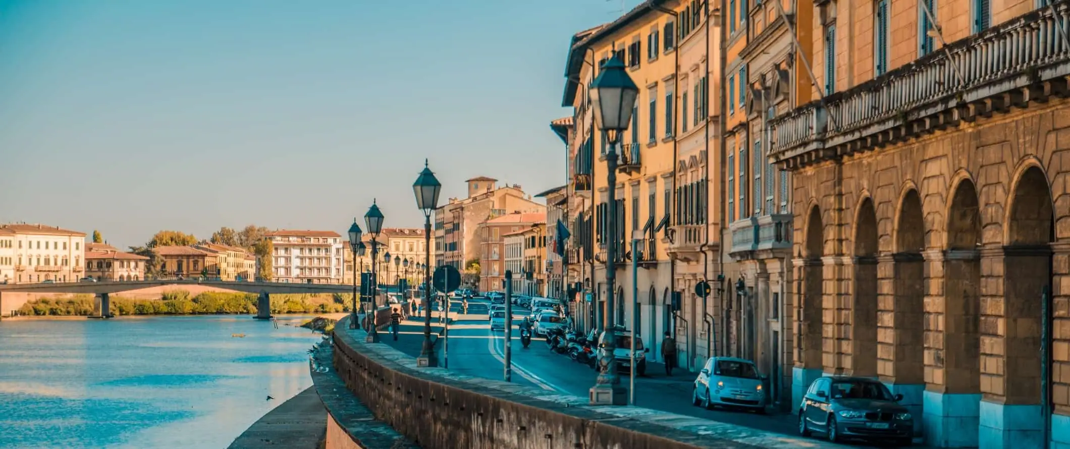 Edifícios e estradas sinuosas ao longo da zona ribeirinha de Pisa, Itália.