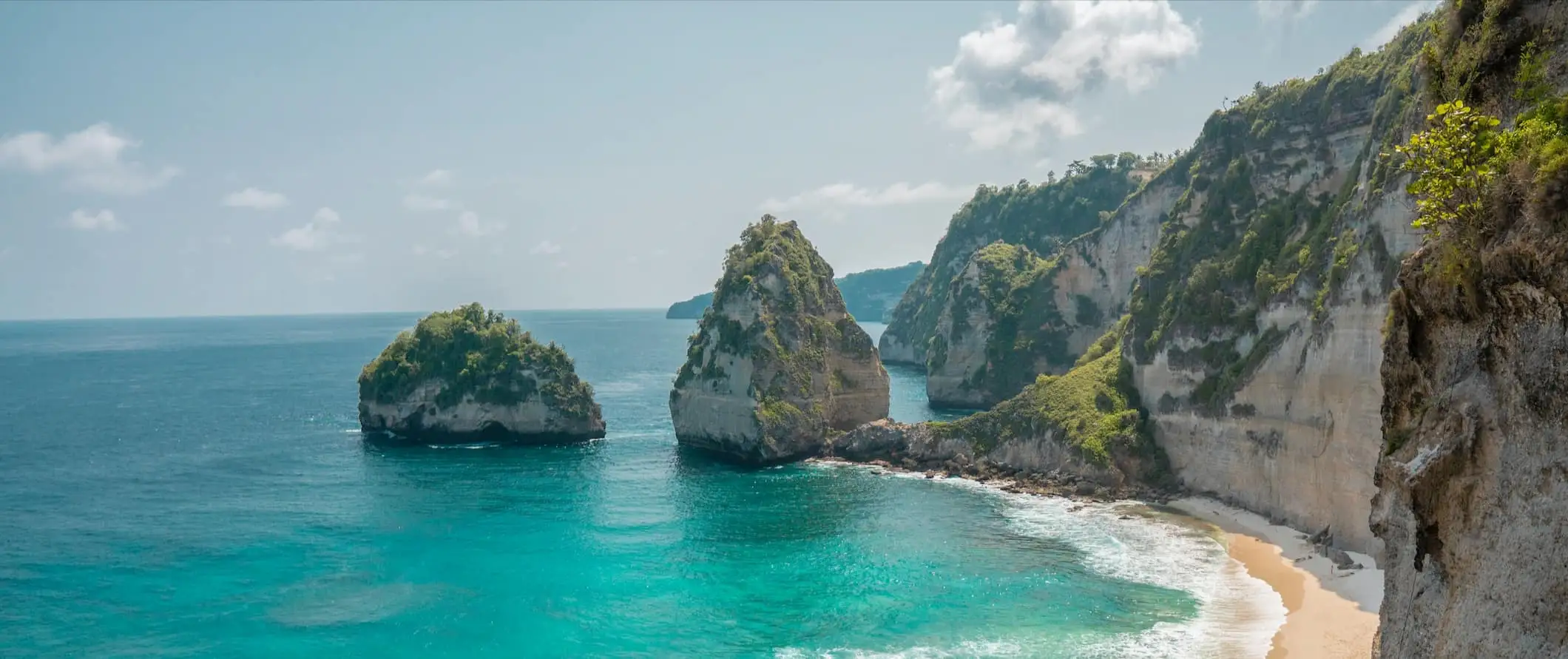 Osupljiva plaža ob razgibanih pečinah in obali Balija v Indoneziji