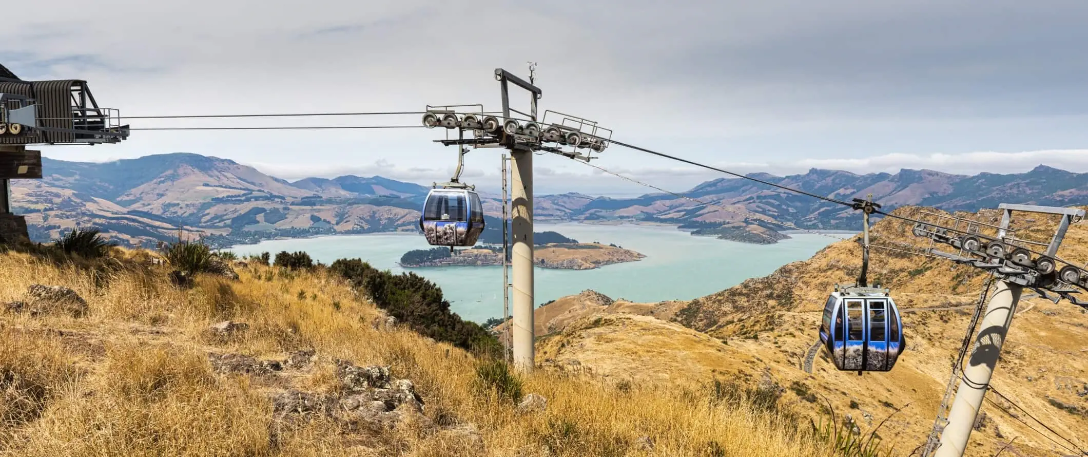 Gondoler med panoramautsikt over fjell og et stort innløp i bakgrunnen, i Christchurch, New Zealand.