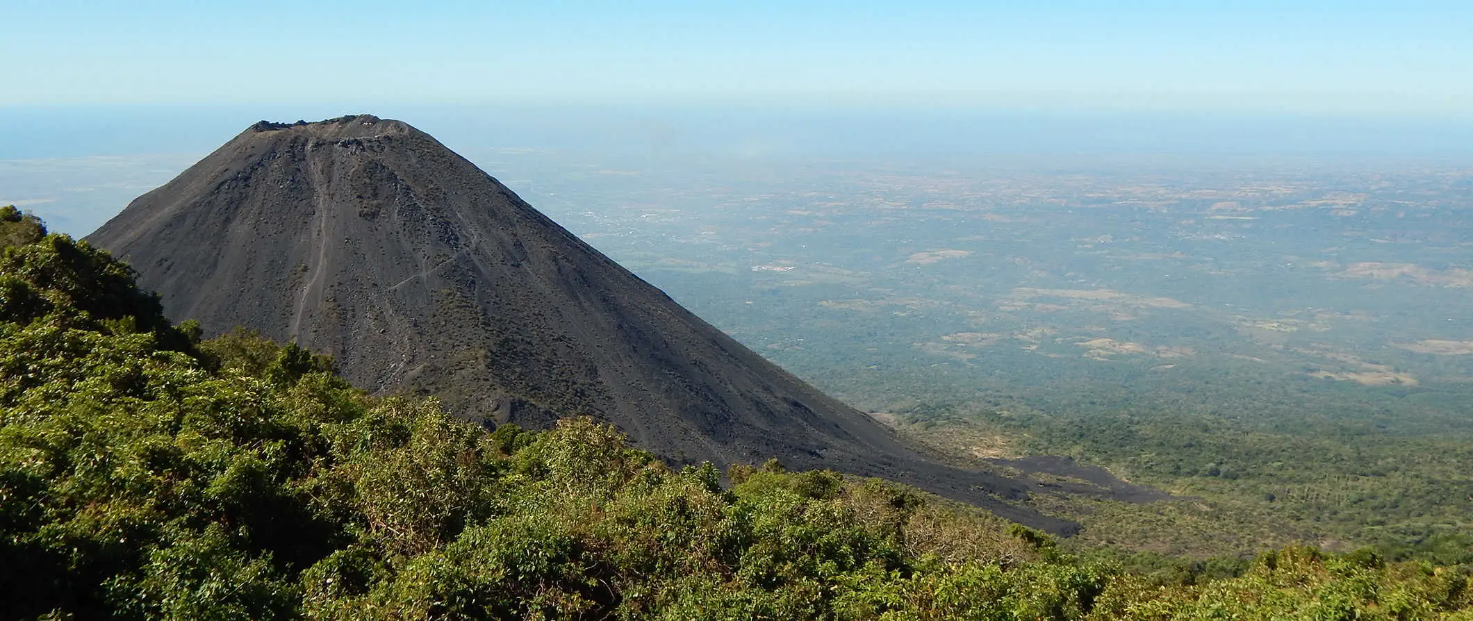 en vulkan i El Salvador omgivet af en vidtstrakt, frodig jungle