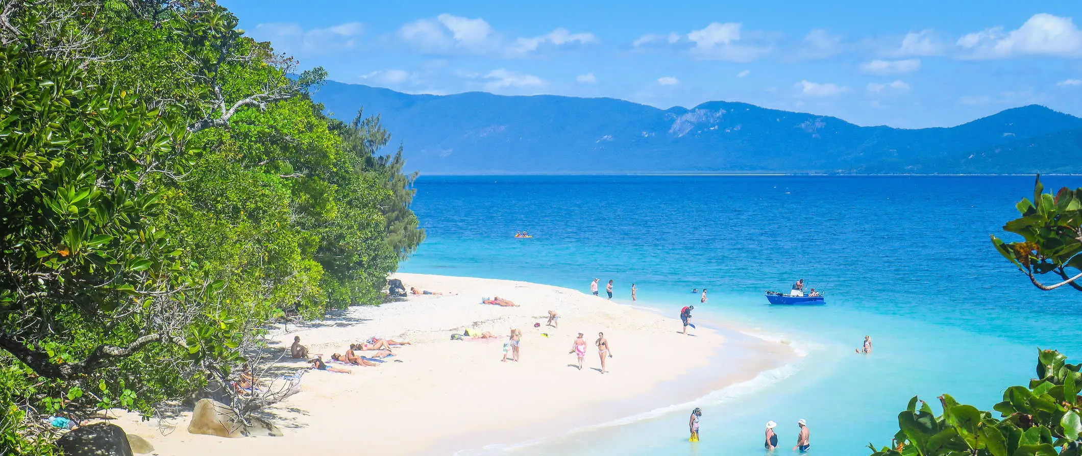 Folk som har det gøy i solen på stranden på en øy nær Cairns, Australia