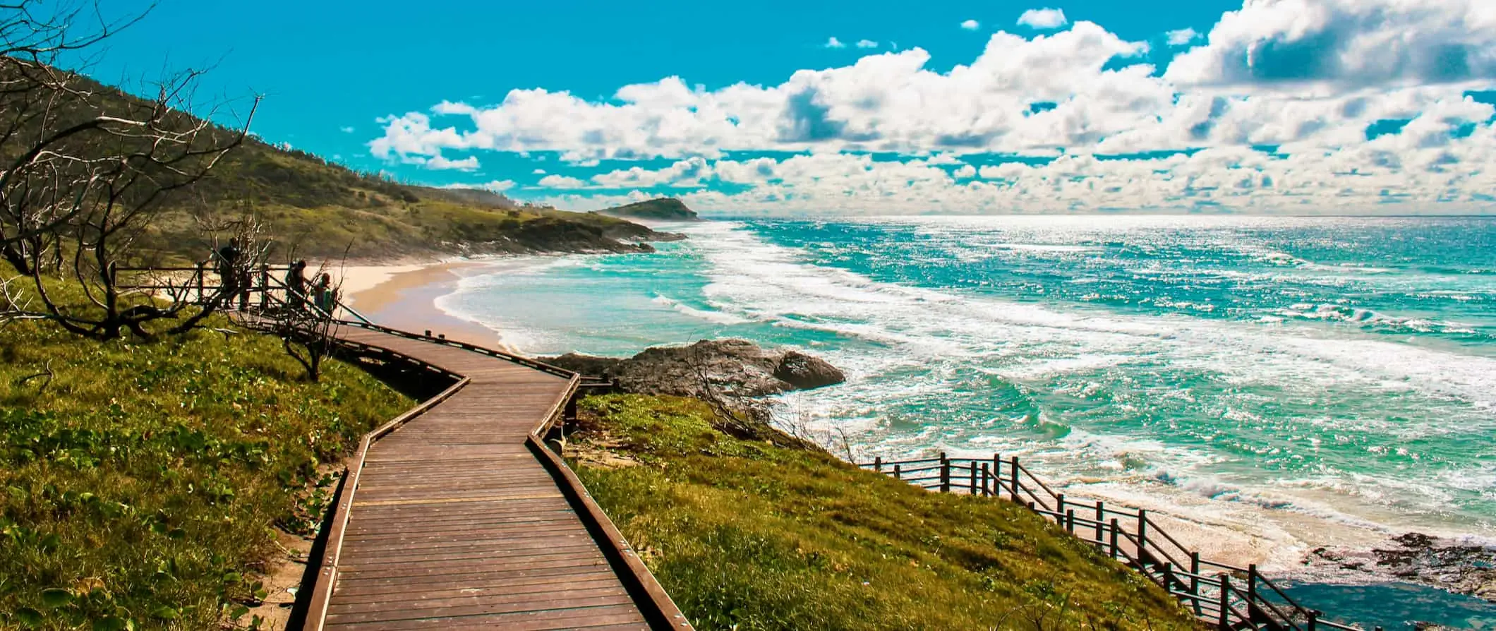 En strandstig i trä som följer den fantastiska kusten på den tropiska Fraser Island i Australien