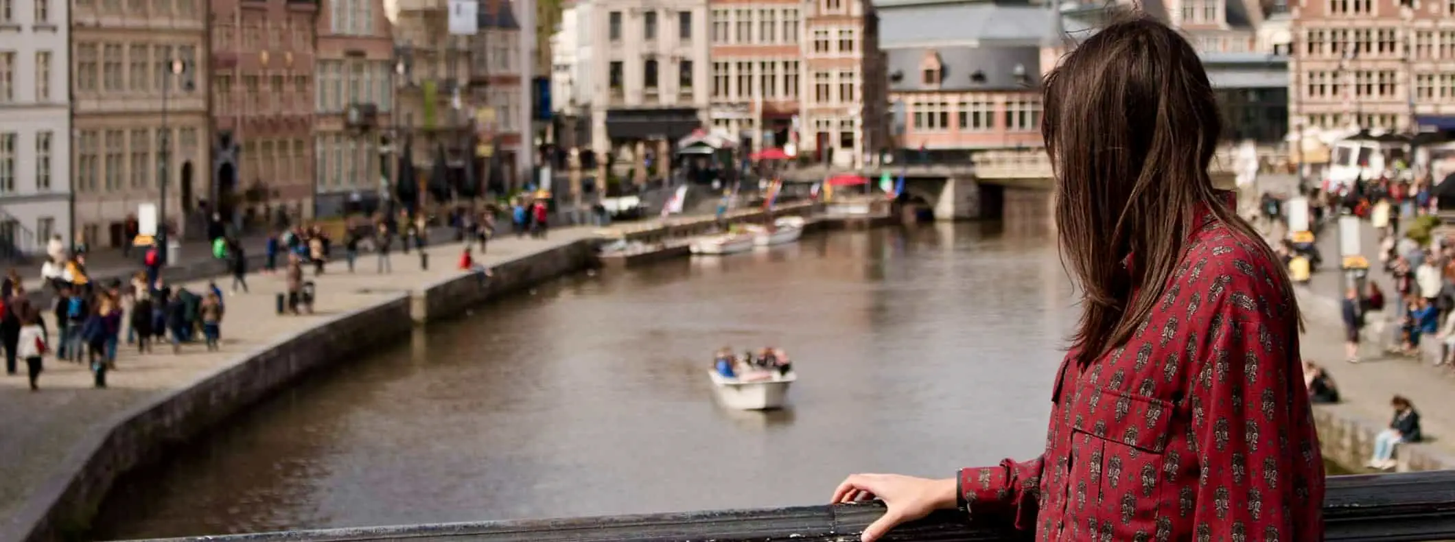 Een vrouwelijke soloreiziger die uitkijkt over een druk stadsbeeld