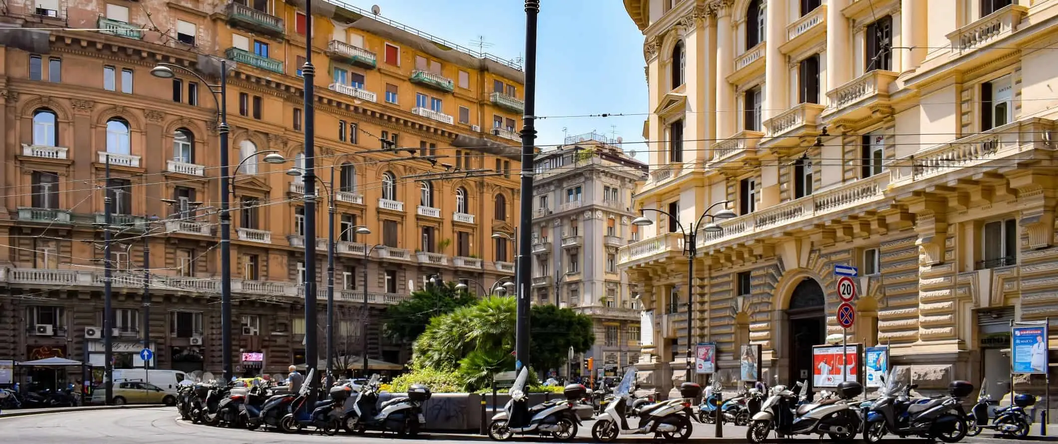 Ciclomotori allineati lungo una strada colorata a Napoli, Italia.