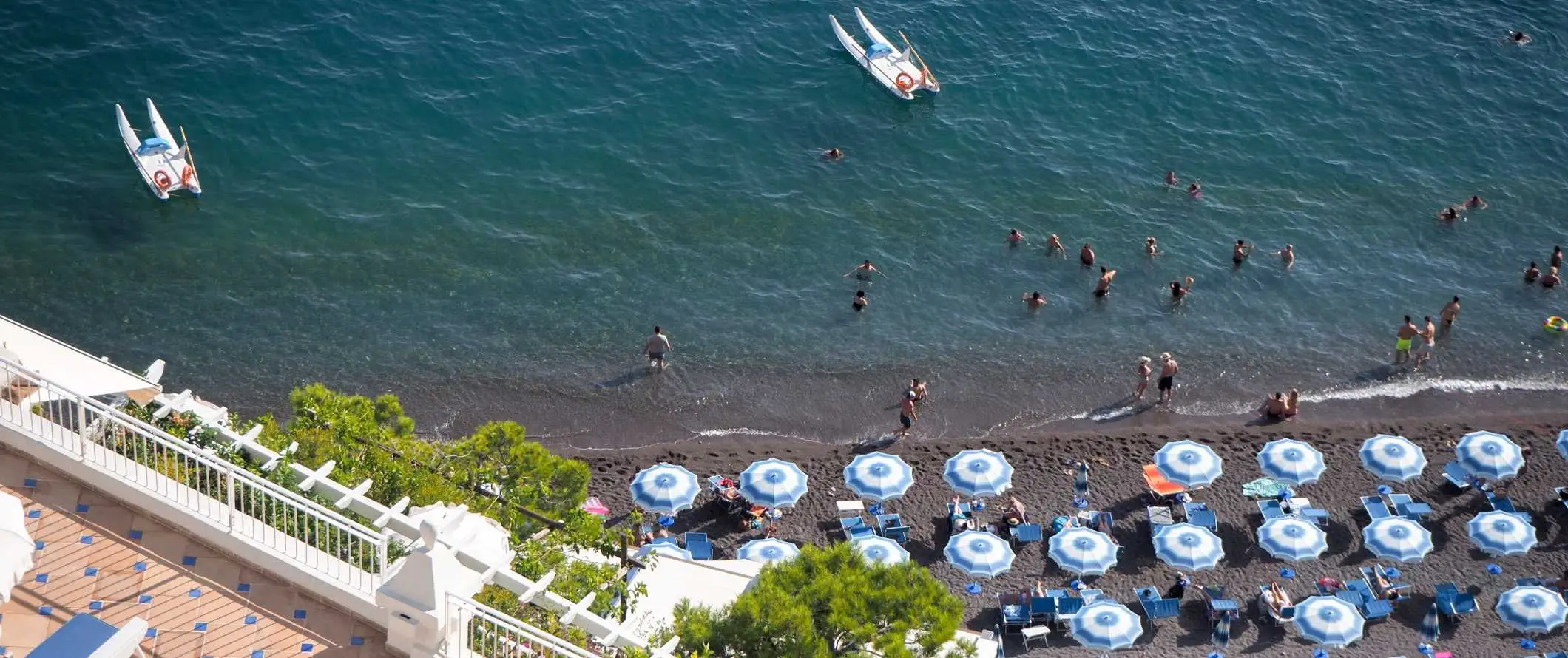 Luchtfoto's van parasols en strandstoelen op het strand in Sorrento, Italië.