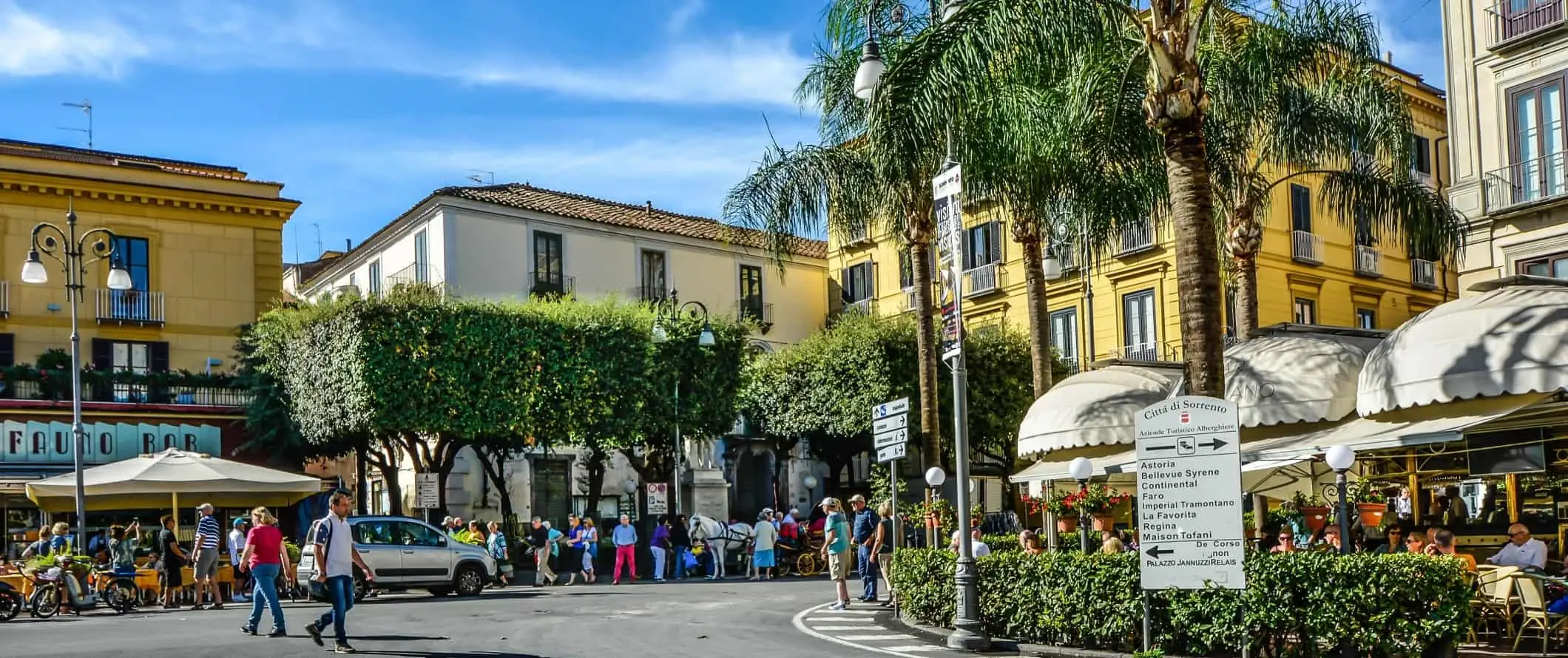 Escena callejera de una animada plaza con gente caminando en Sorrento, Italia.