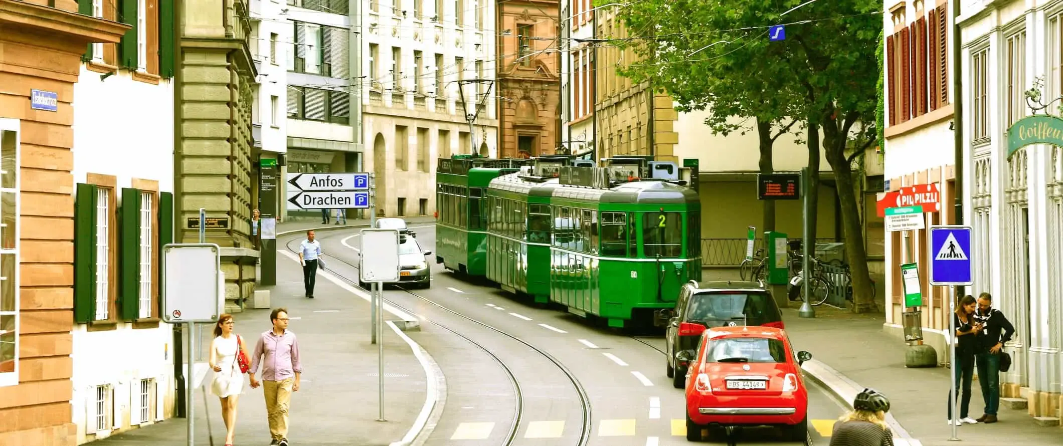 Strada curva con un tram che scende a Basilea, in Svizzera