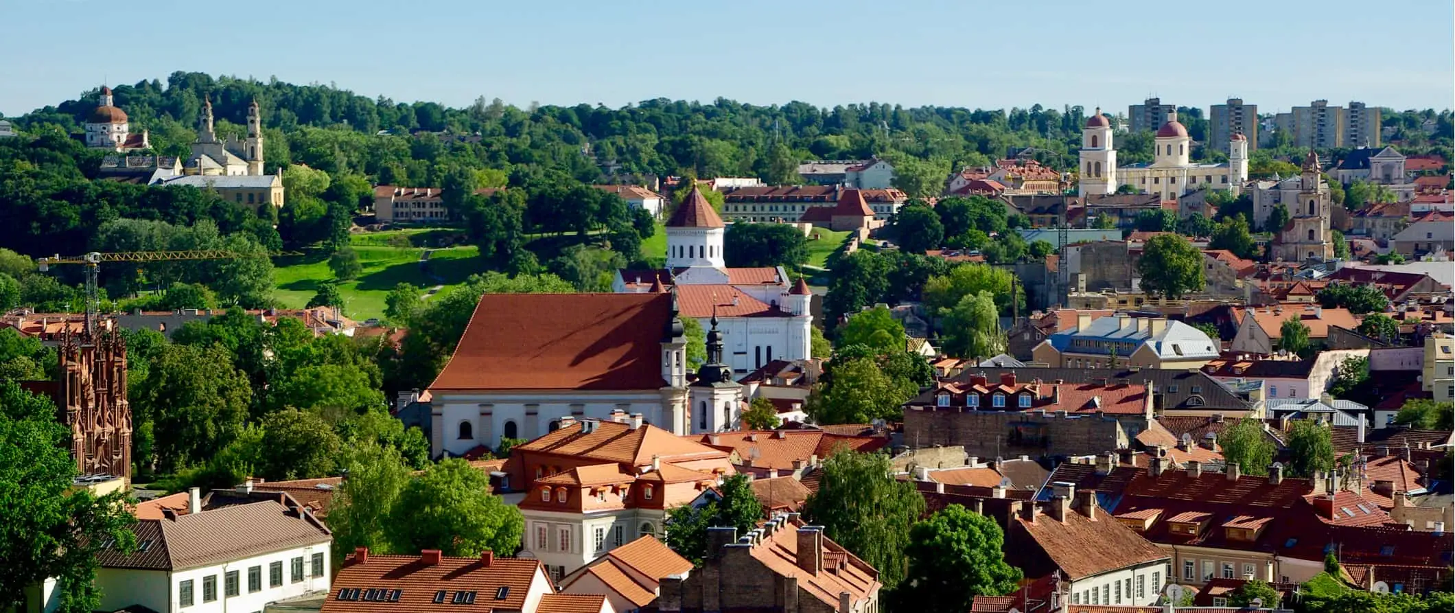 Historické budovy obklopené svěžími zelenými lesy v Litvě za slunečného dne