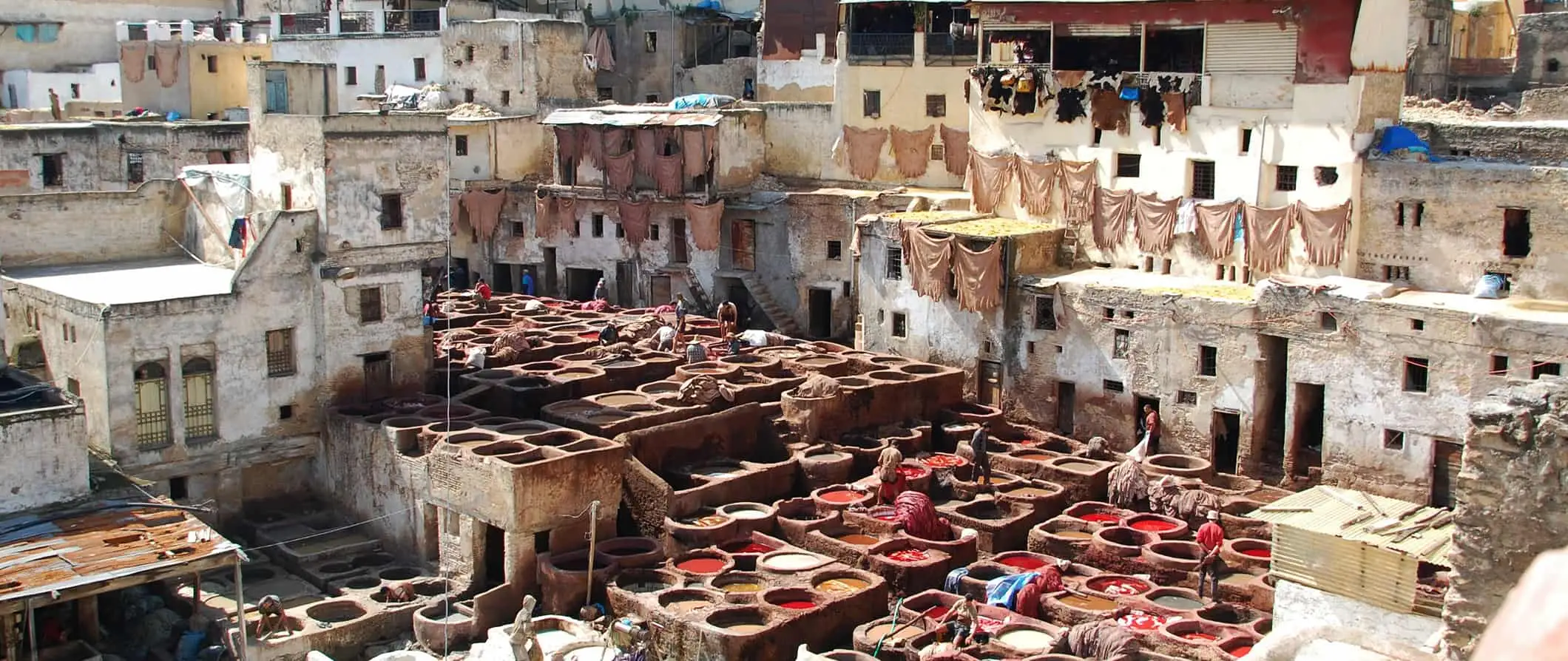 Die riesige, historische Gerberei in Fes, umgeben von alten, traditionellen marokkanischen Häusern und Gebäuden