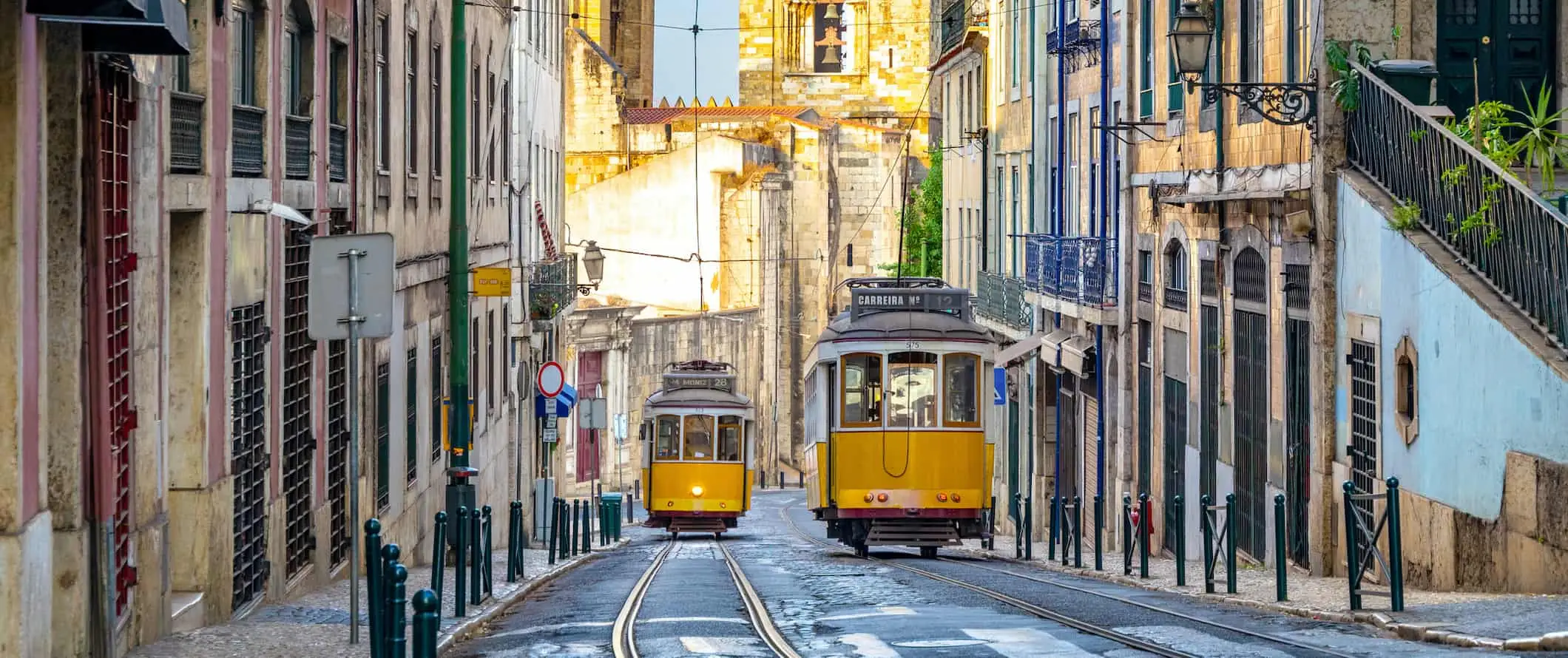 Staré žluté pouliční auta na úzké ulici v barevném městě Lisabon, Portugalsko