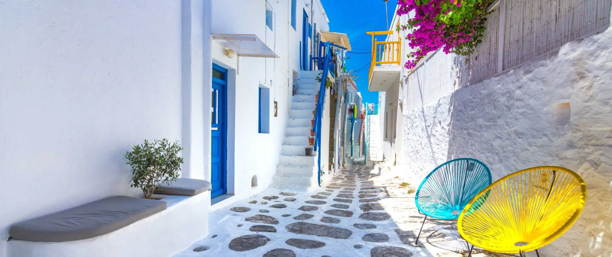 Rue de la vieille ville de Mykonos avec des bâtiments blanchis à la chaux avec des portes et fenêtres bleues sur l'île de Mykonos en Grèce.