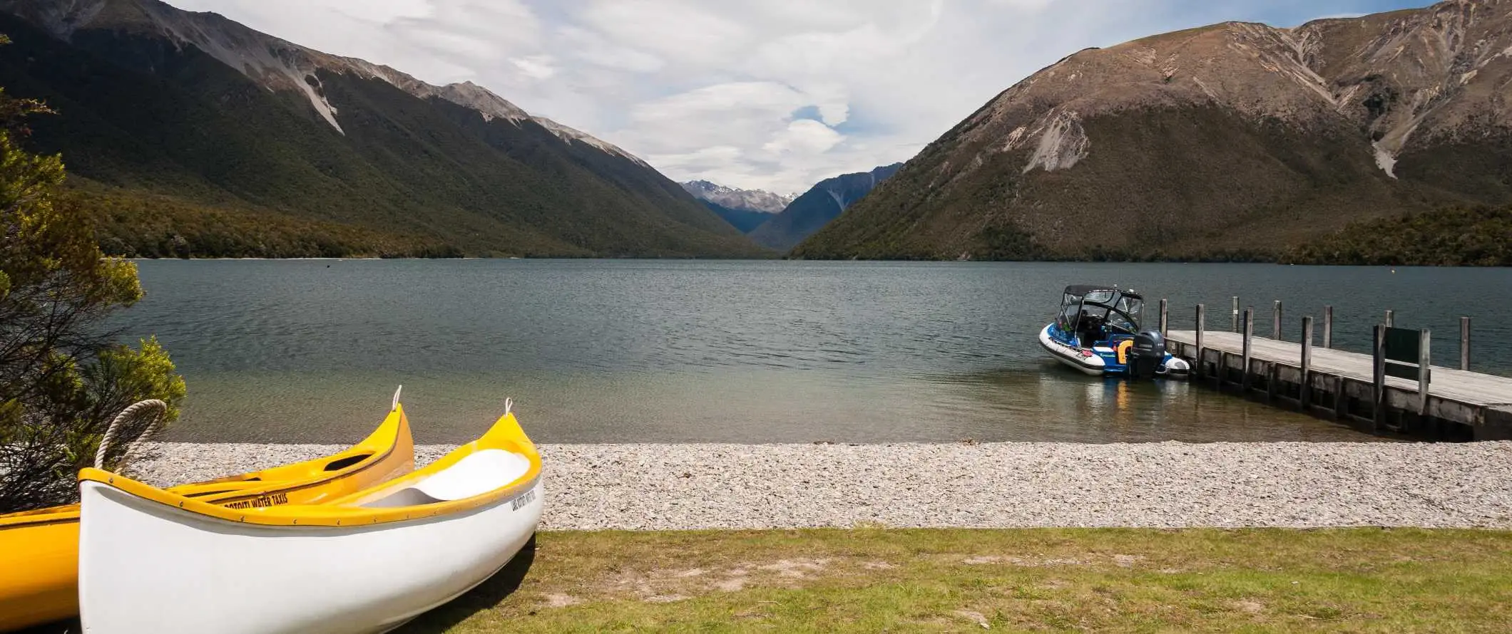 Kano langs vandet med bjerge i baggrunden nær byen Nelson, New Zealand.