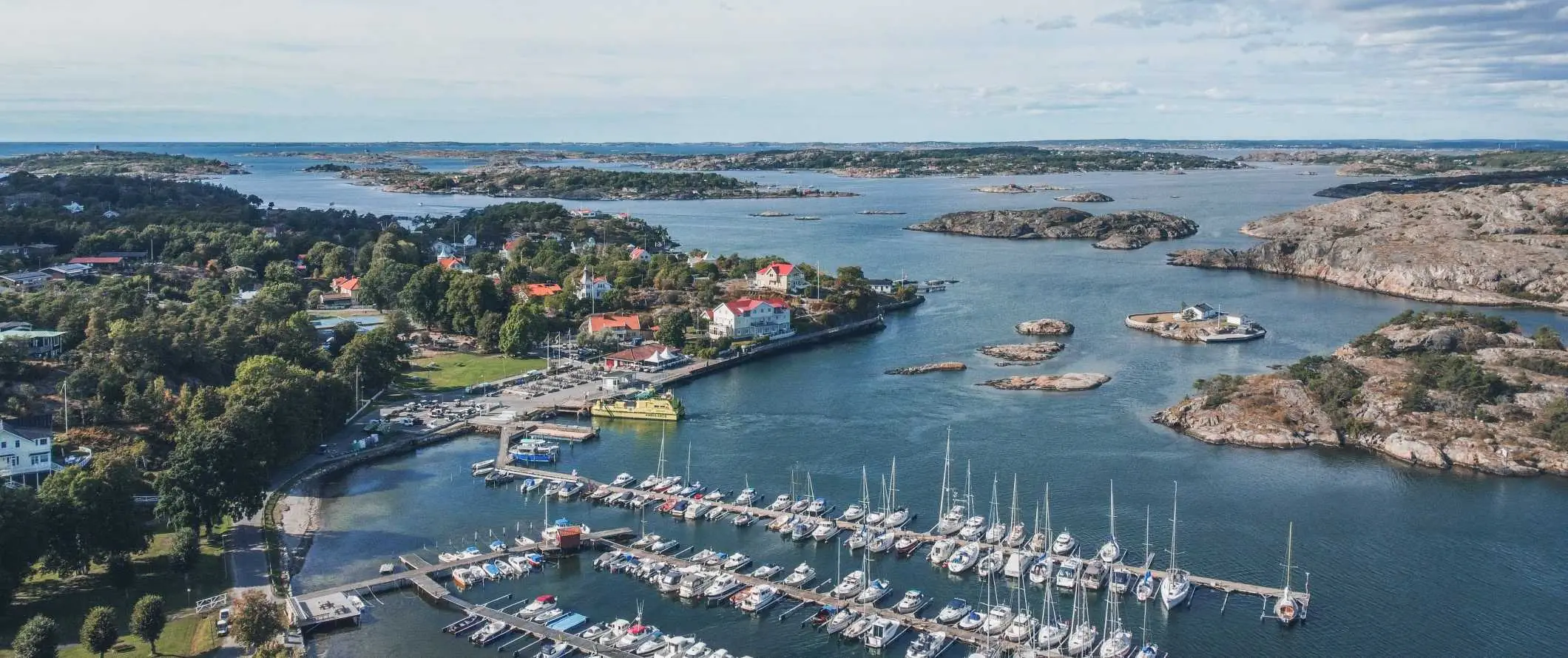 İsveç'in Göteborg kentinde arka planda yelkenli tekneler ve adalarla dolu bir limanın havadan görünümü