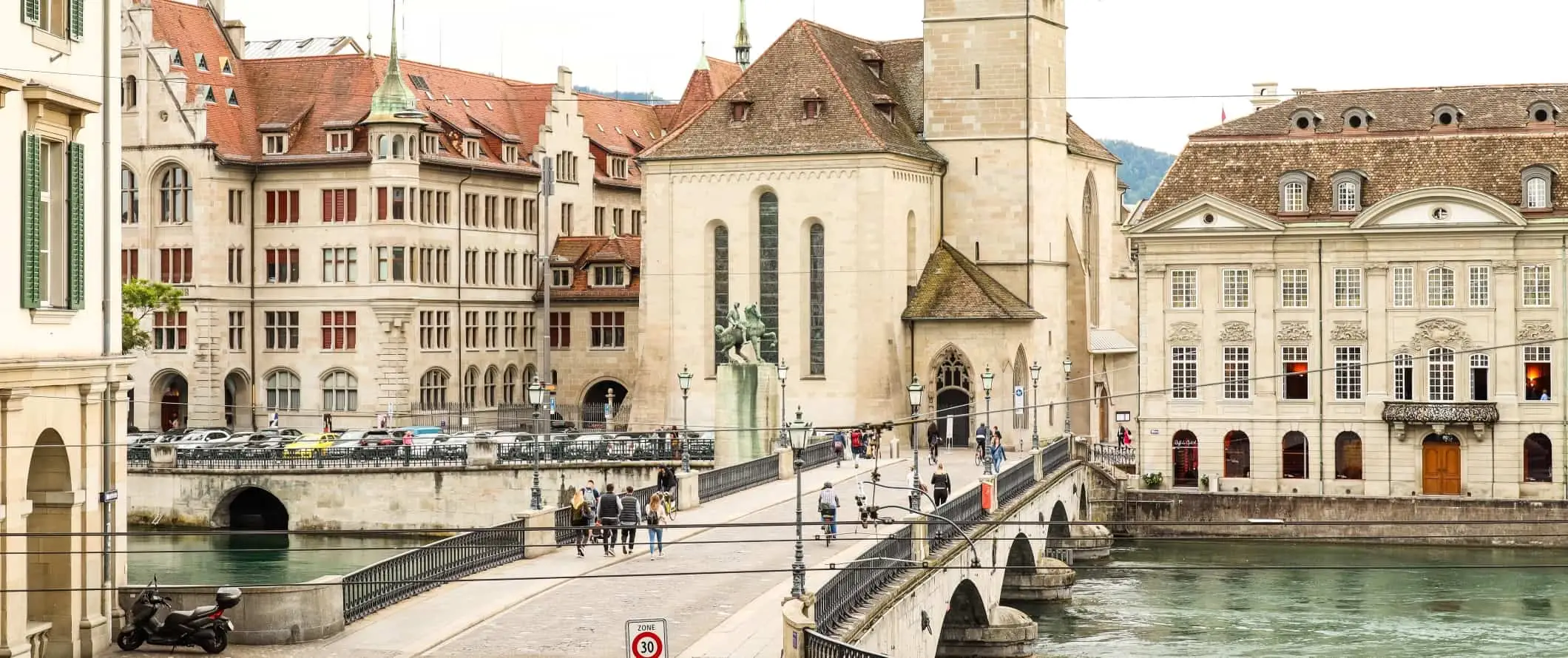 Folk som går over en steinbro i det historiske sentrum av Zürich, Sveits