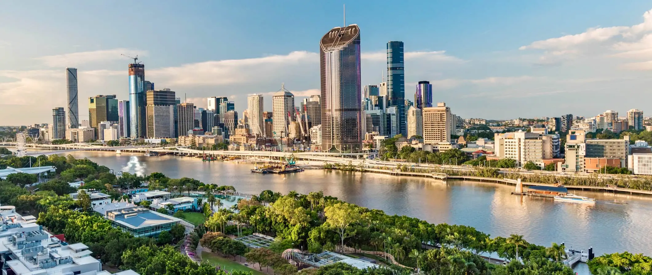 Den tårnhøje skyline af Brisbane, Australien med masser af grønt på tværs af floden