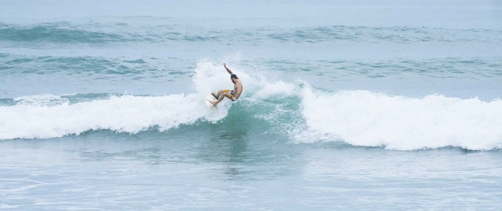 Ein Surfer fängt eine Welle vor der Küste von Tamarindo in Costa Rica