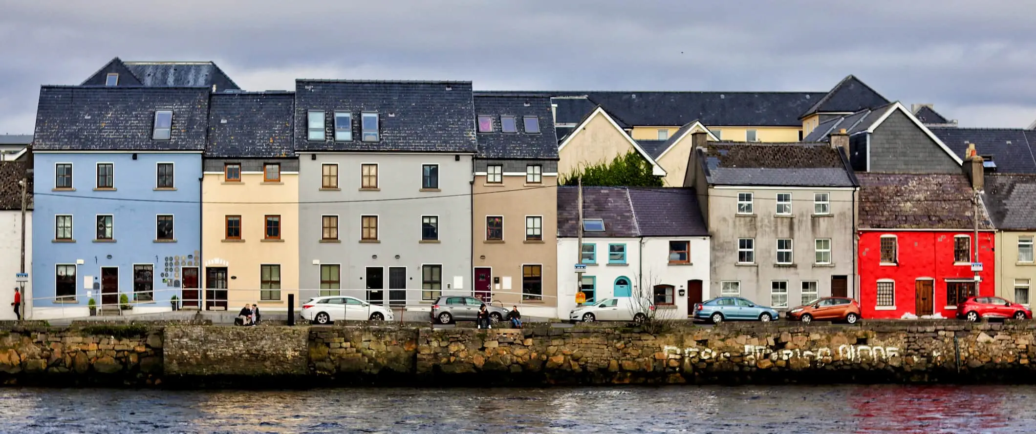 Galway, İrlanda ve sahil boyunca renkli evlerin bulunduğu sahil manzarası