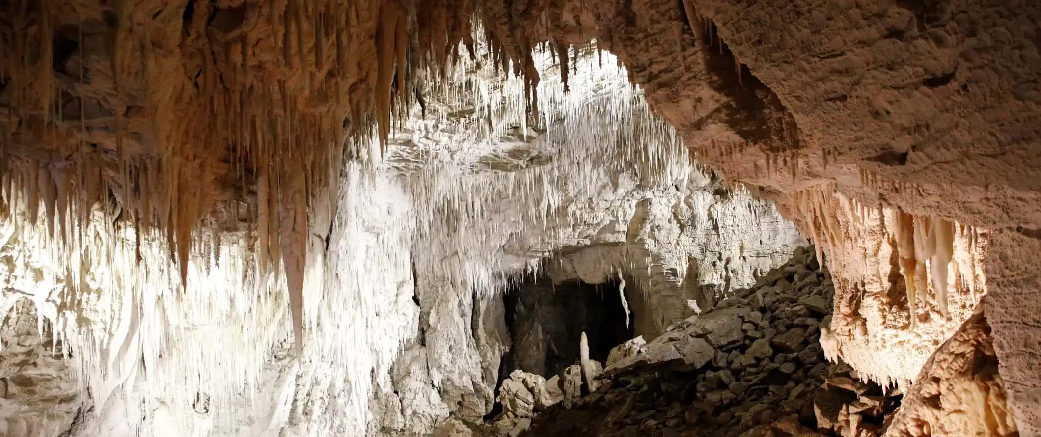 Tampilan jarak dekat dari staglatit dan stalagmit di gua berbatu di Waitomo, Selandia Baru.