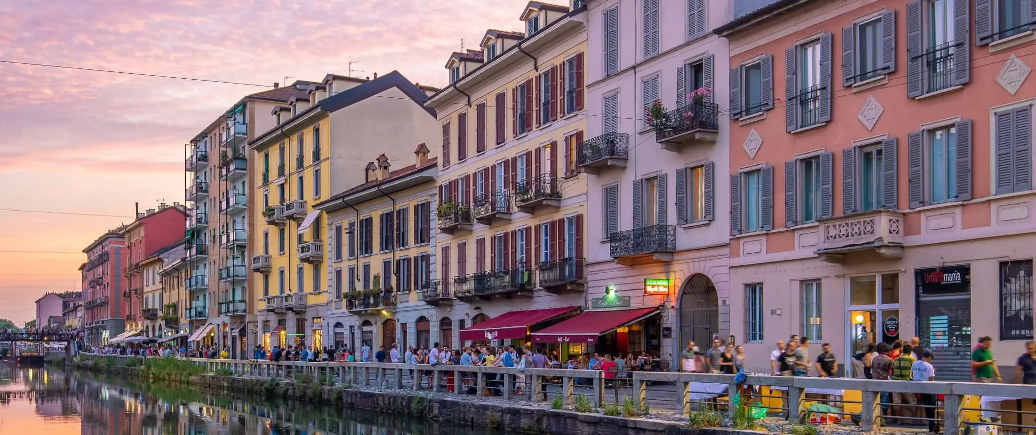 Farverige bygninger langs en kanal ved solnedgang i Naviglio Grande-distriktet i Milano, Italien.