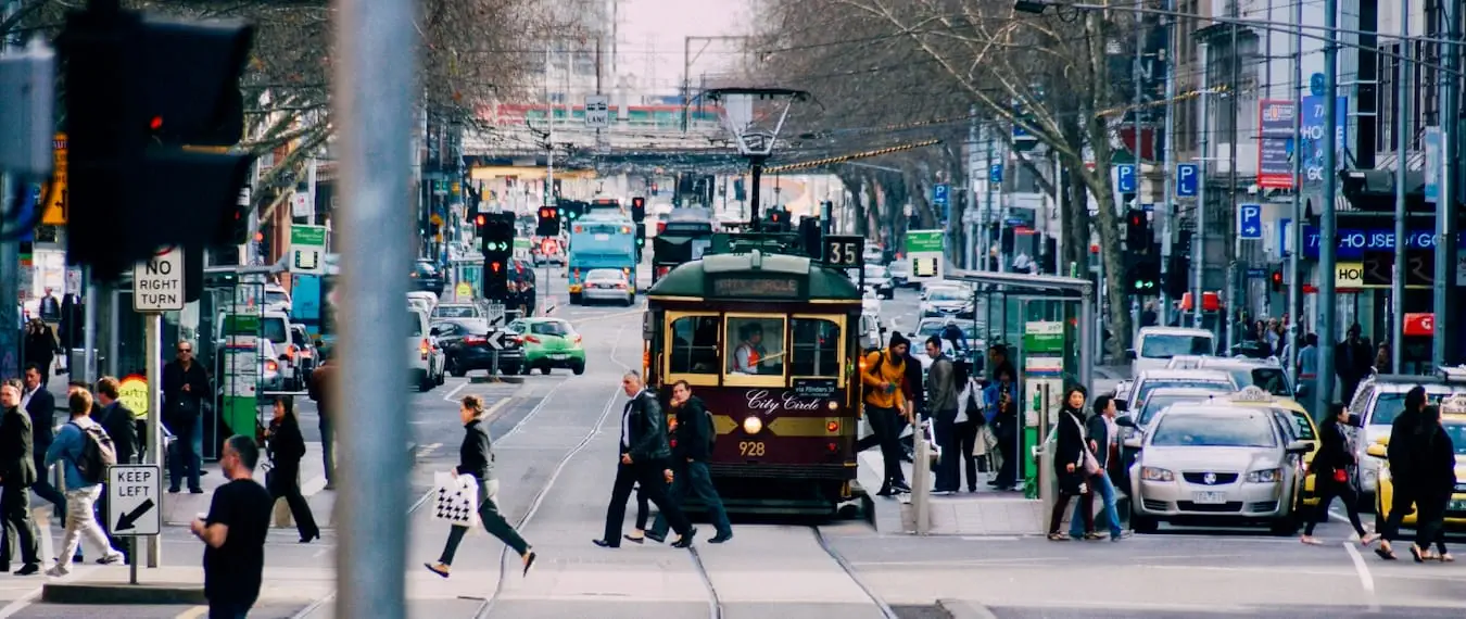 Ludzie chodzą i jeżdżą tramwajem w centrum Melbourne w Australii