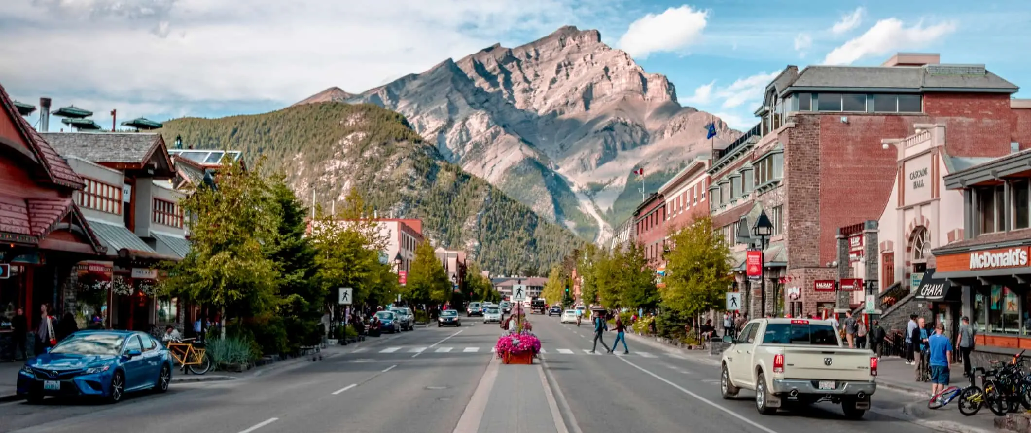 En lugn gata i Banff, Alberta med höga berg i fjärran