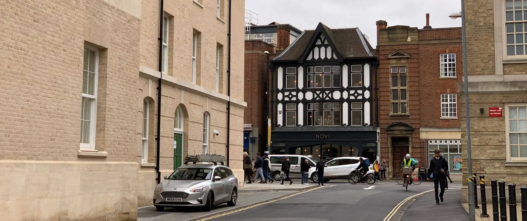 Tanawin sa kalye na may makasaysayang Tudor-style na gusali sa background sa Cambridge, England