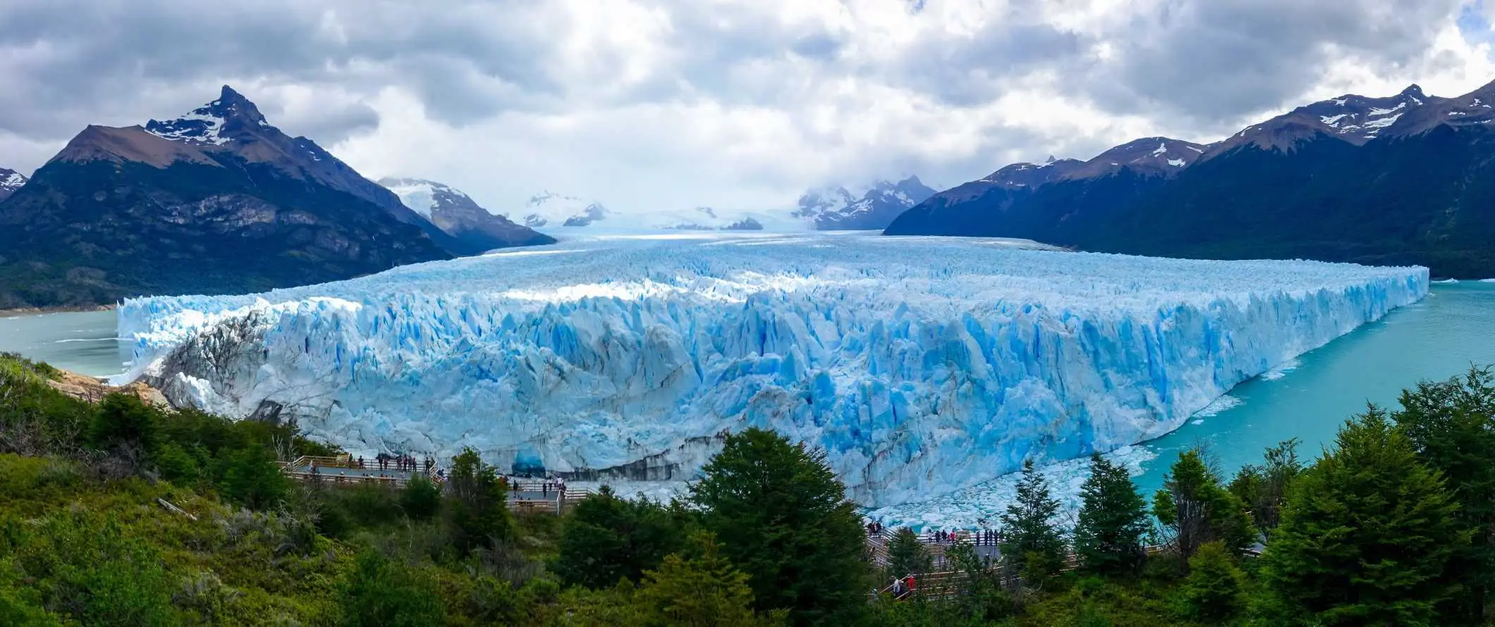 Patagonian, Argentiinan upeat, kohoavat vuoret turmeltumattoman sinisen taivaan alla, jossa on suuri jäätikkö etualalla