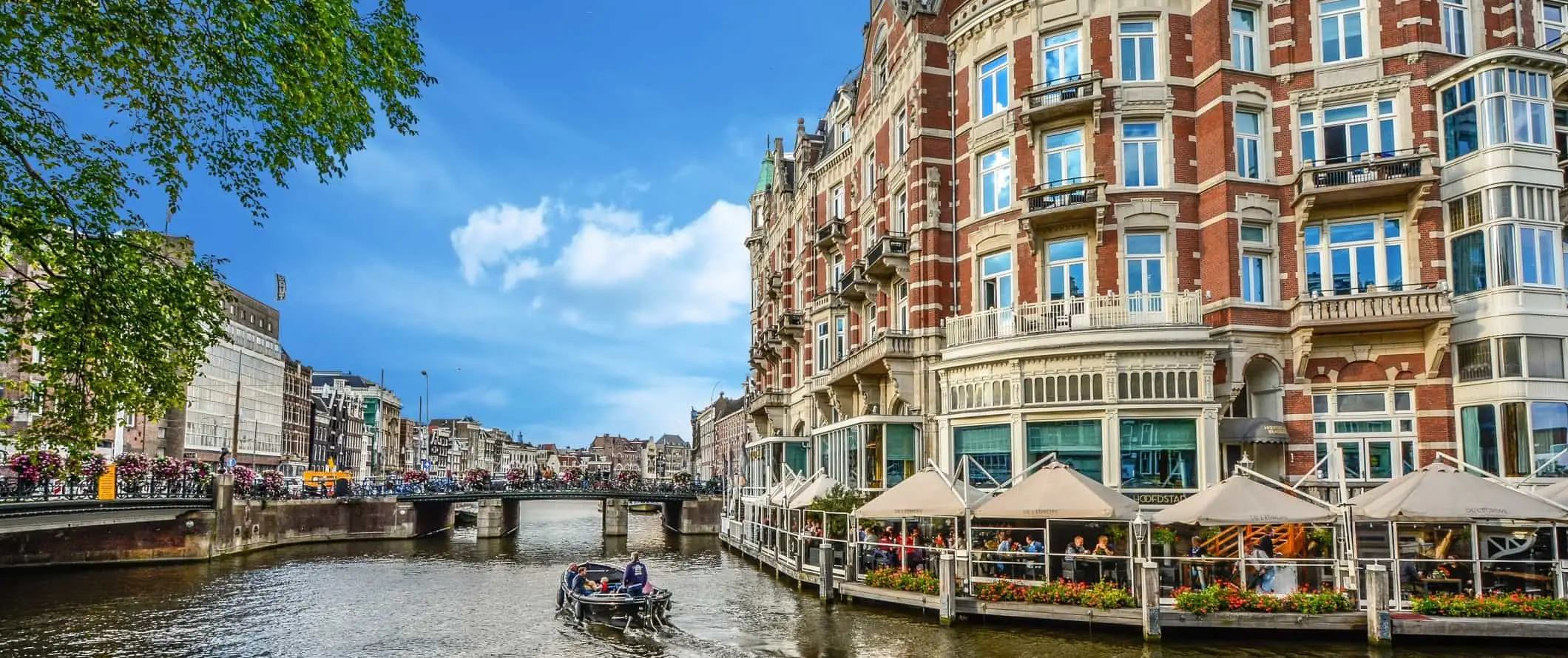 Båt cruiser ned en sving i en kanal i Amsterdam, Nederland.