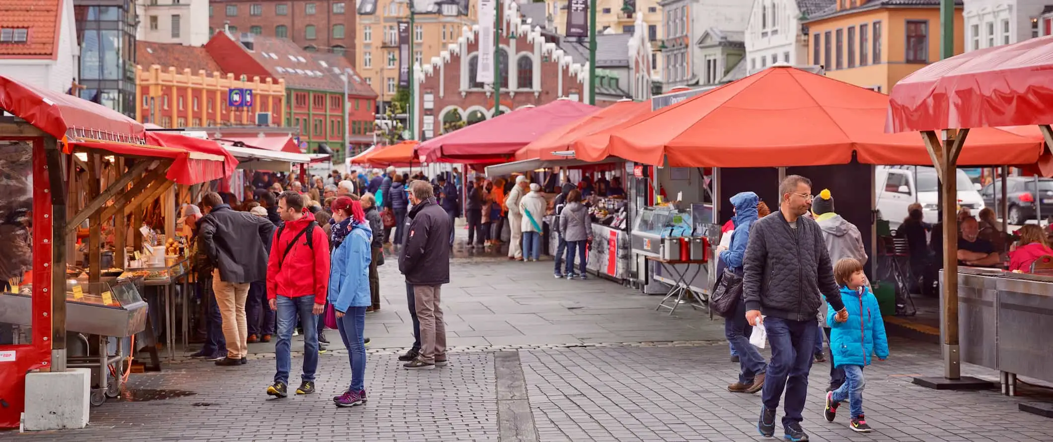 Persone che esplorano il vivace mercato del pesce in una giornata di sole a Bergen, Norvegia