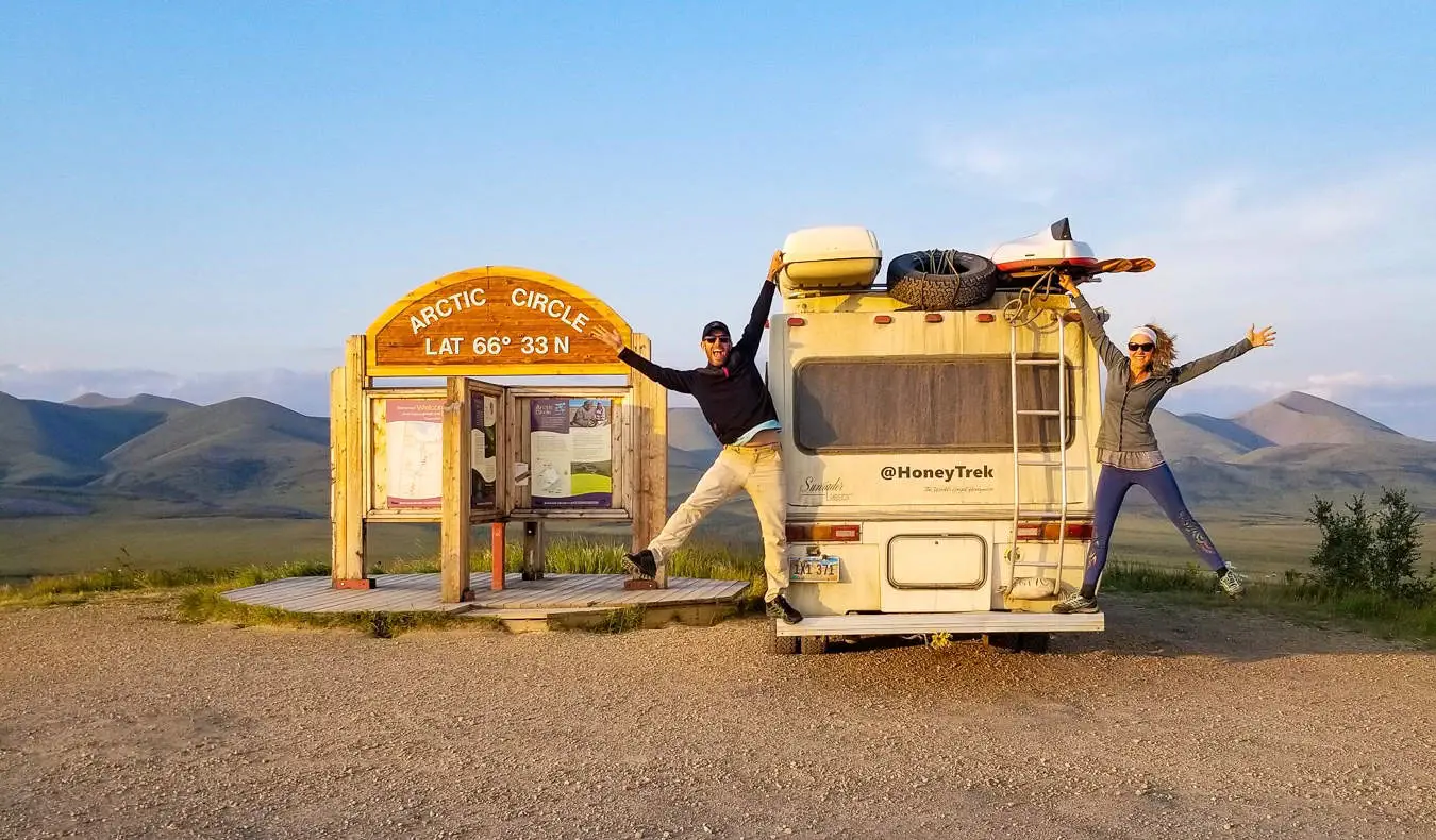 Dua pelancong berpose untuk foto lucu di samping RV mereka