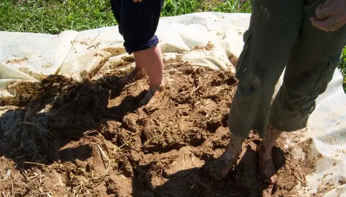 Una persona que trabaja en la tierra mientras cultiva en el extranjero.