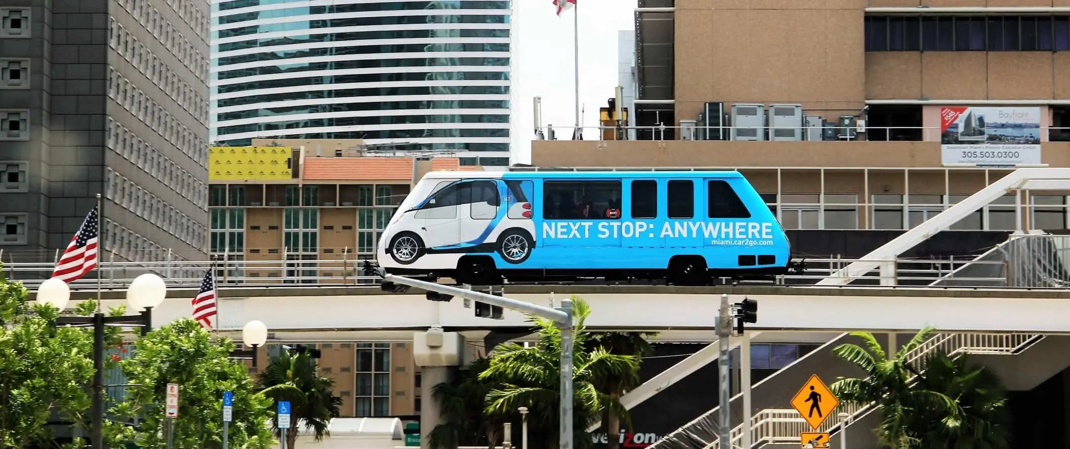 Tàu điện ngầm metromover màu xanh được bao quanh bởi các tòa nhà cao tầng ở trung tâm thành phố Miami, Florida