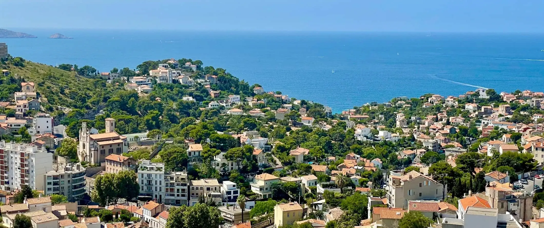 De böljande kullarna i staden Marseille, Frankrike, med Medelhavet i bakgrunden