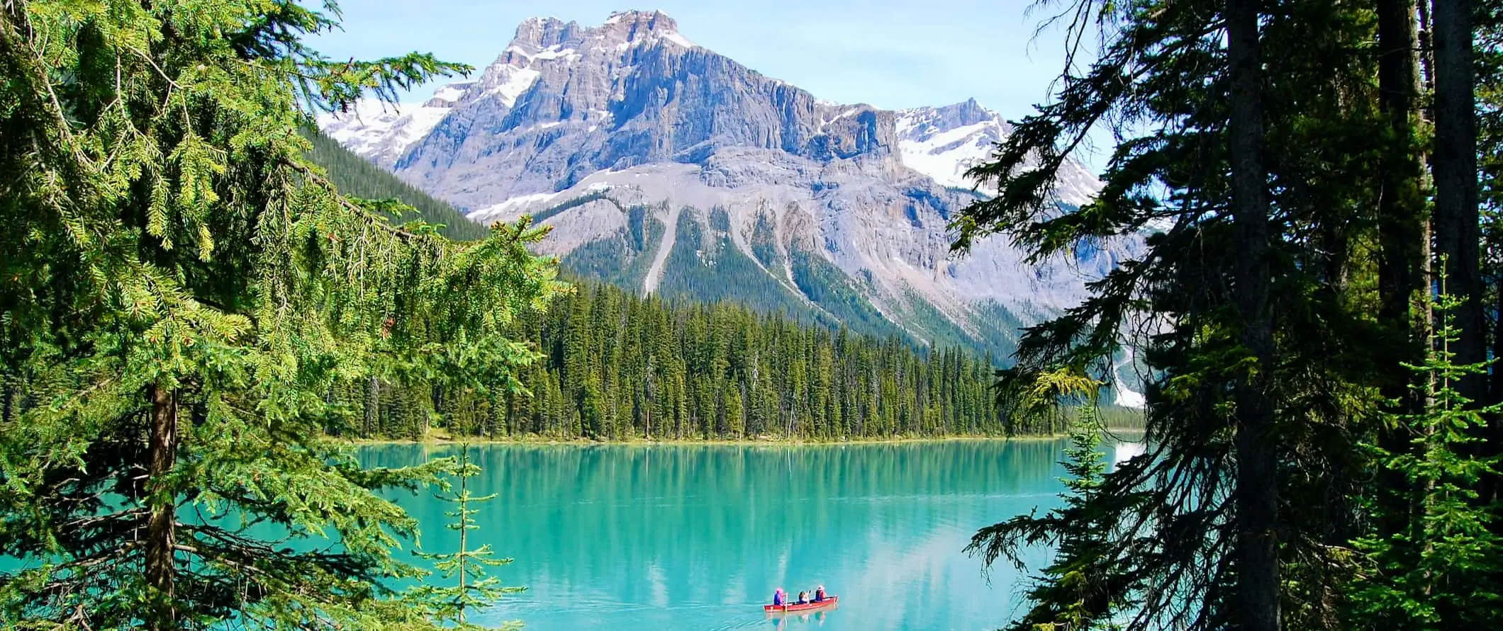 Isang tao sa isang maliit na kayak sa tahimik na tubig ng Lake Louise malapit sa Banff, Alberta