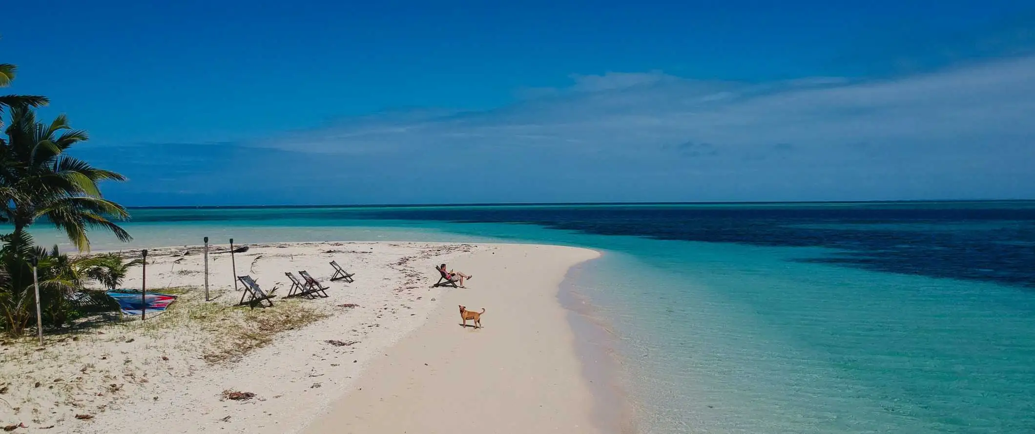 Een persoon loungen in een strandstoel op een afgelegen strand in Fiji