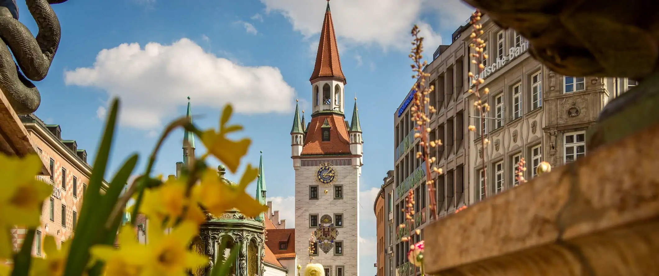 Zgodovinsko staro mestno jedro Münchna v Nemčiji spomladi z rožami, ki cvetijo v bližini cerkve