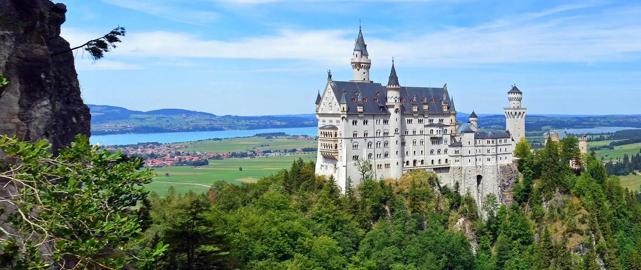 Det ikoniske slottet Neuschwanstein, Tyskland, står høyt over det omkringliggende grøntområdet i Bayern