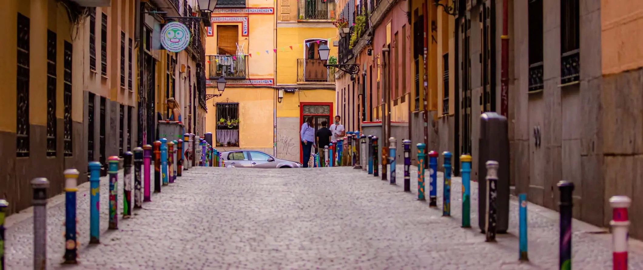 Uma estreita rua de paralelepípedos envolvida por edifícios antigos em Madrid, Espanha