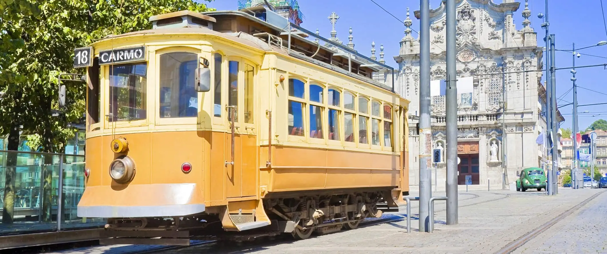 Klassikaline kollane tänavaauto päikesepaistelisel päeval Portugalis Portos