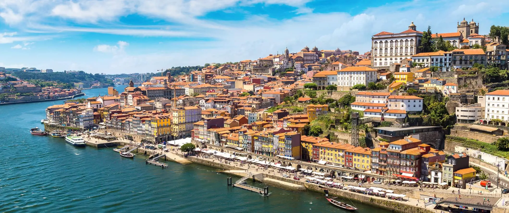 Porto, Portugal og dens farverige bygninger på bjergsiden set fra Douro-floden