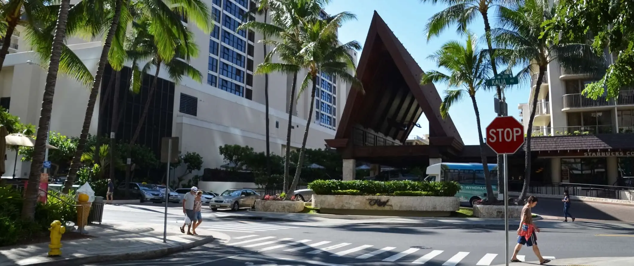 Ludzie idący ulicą pod palmami w Honolulu na Hawajach.