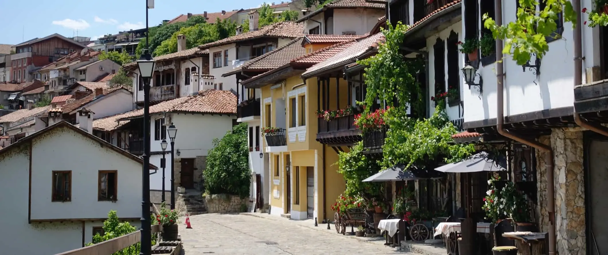 Kopfsteinpflasterstraße, gesäumt von traditionellen Häusern und Restaurants in der Altstadt von Veliko Tarnovo, Bulgarien