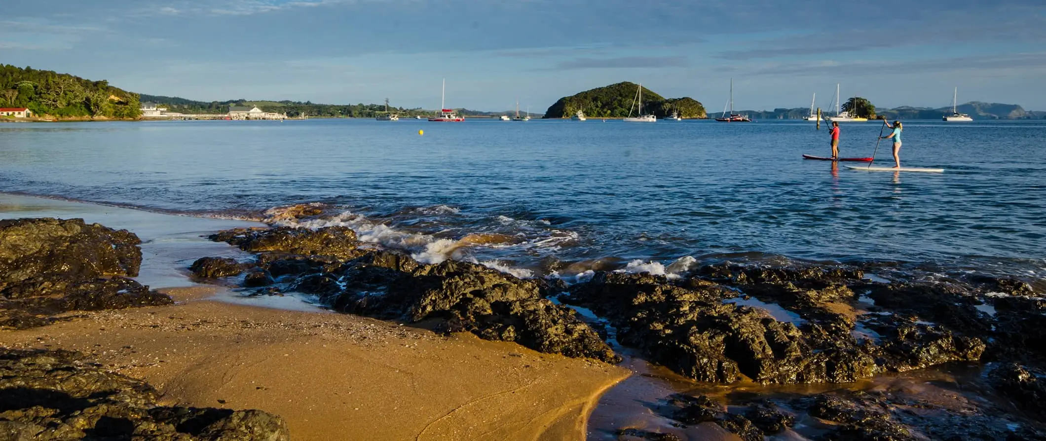 emberek stand-up evezés a Bay of Islands, Új-Zélandon