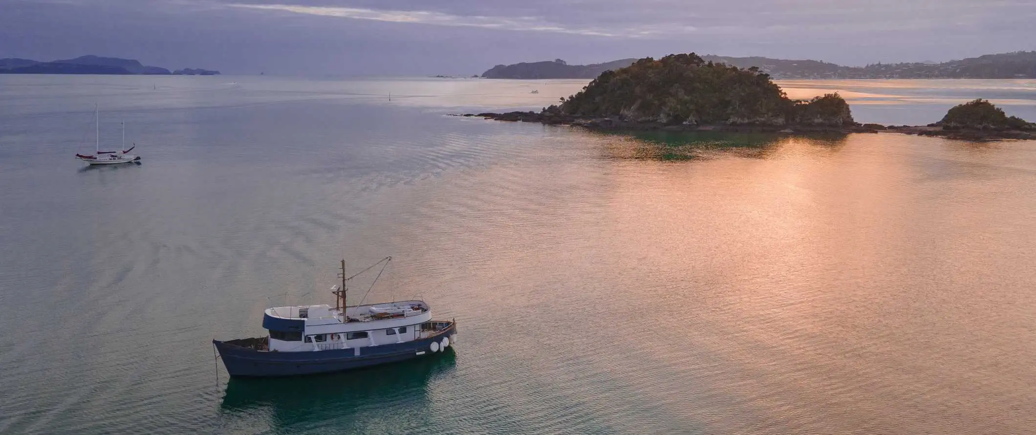 Hajók közlekednek a szigetek között a Bay of Islands-ben, Új-Zélandon