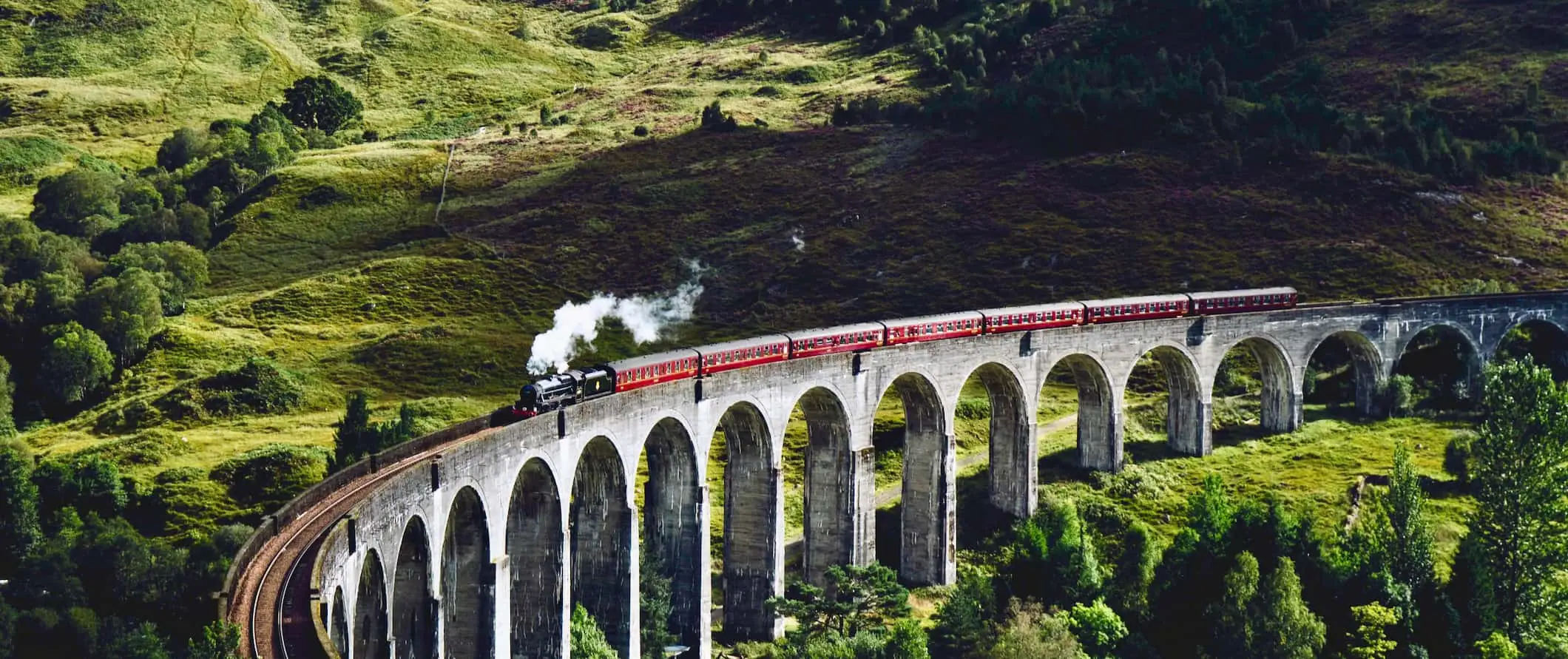 Celebrul tren cu aburi de la Harry Potter traversează un pod vechi din Scoția